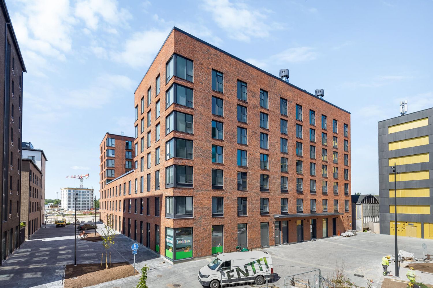 Yhteiskuntakiinteistö, jossa on toimintaa eri-ikäisille ihmisille. 1. kerroksessa on 70-paikkainen ja 4-ryhmäinen päiväkoti. Päiväkodilla on sisäpihalla oma leikkipiha. Lisäksi autohallin katolla on valtava kattopiha, jossa on päiväkodille rajattu oma alueensa jättihiekkalaatikkoineen. Kerroksissa 2...