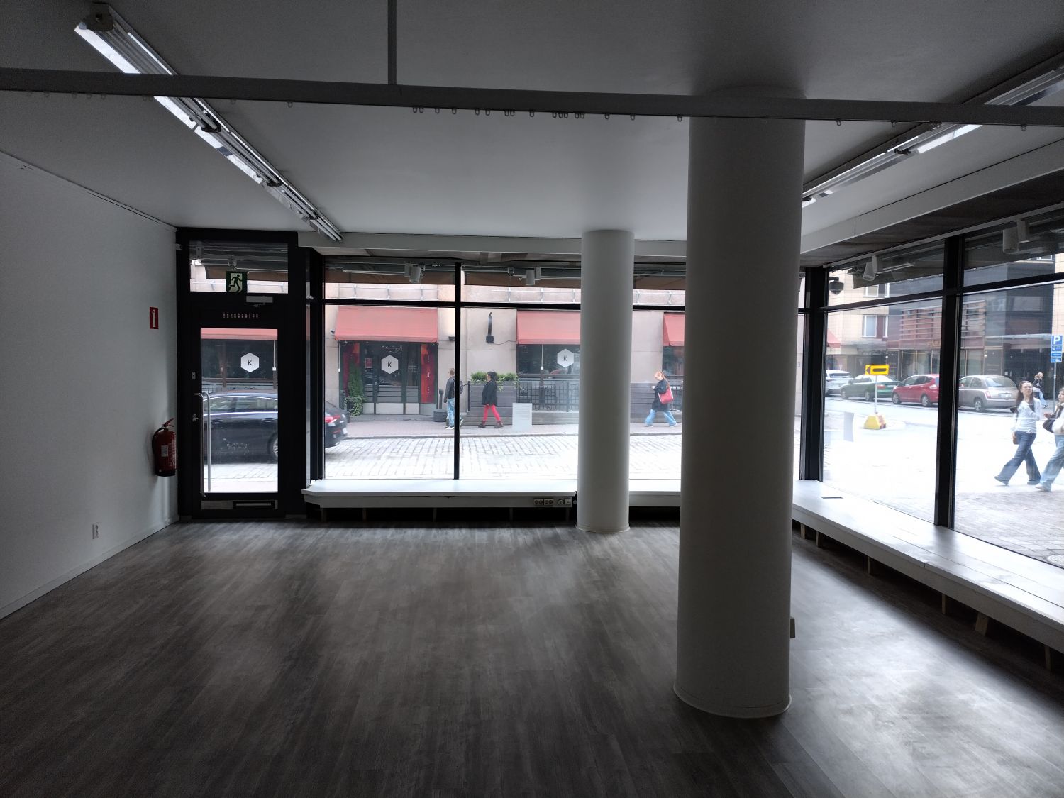 Sisäänkäynti ja näyteikkunat Kauppakadulle. Huom!  Lämpöpatterit ikkunapenkkien alla.