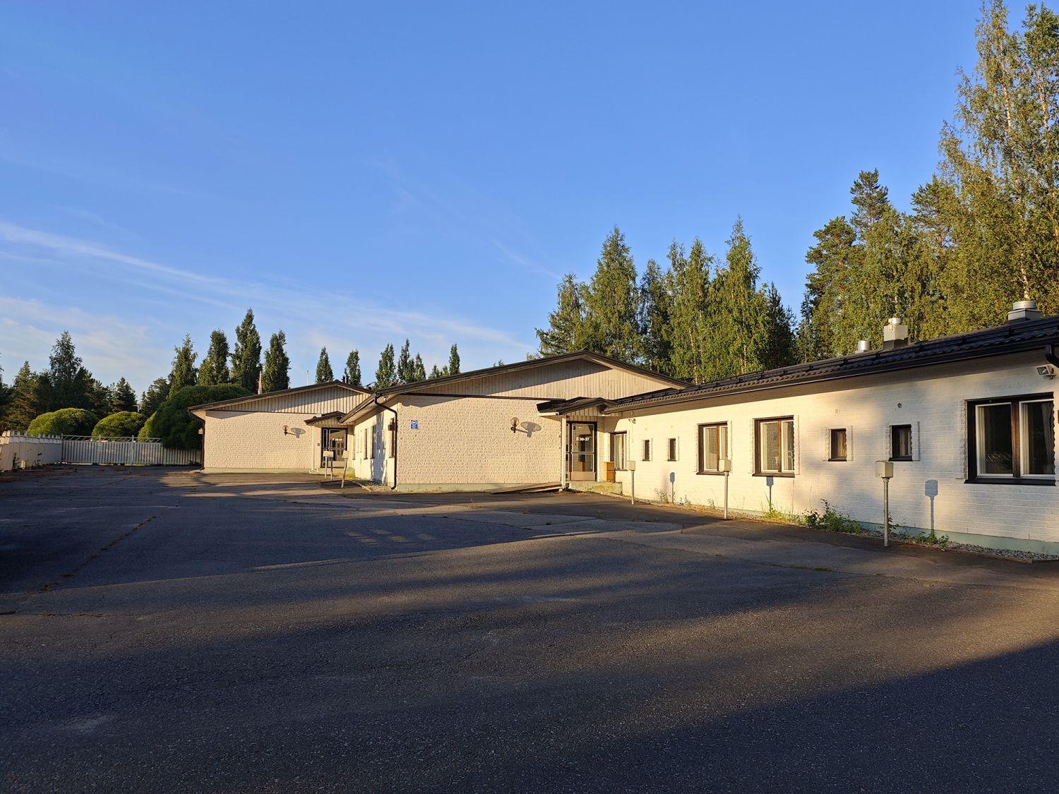 Hotellikiinteistön julkisivu ja asfaltoitu piha-alue.