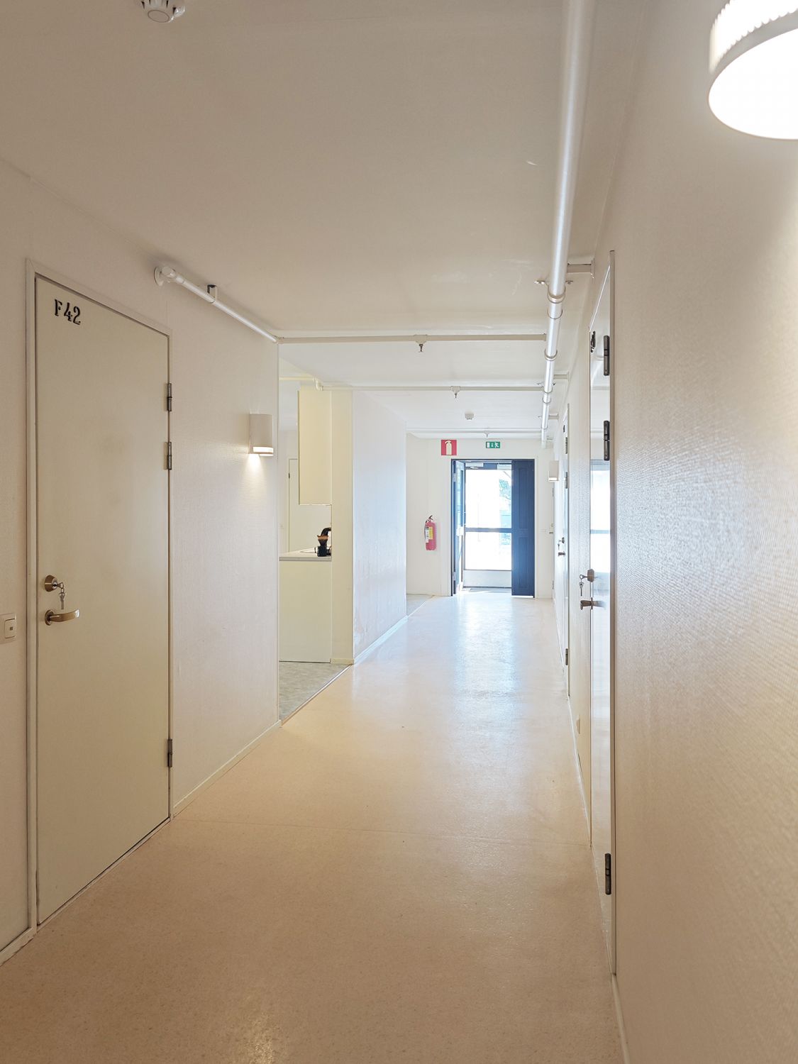 Valoisa käytävä ja kulku majoitushuoneisiin.