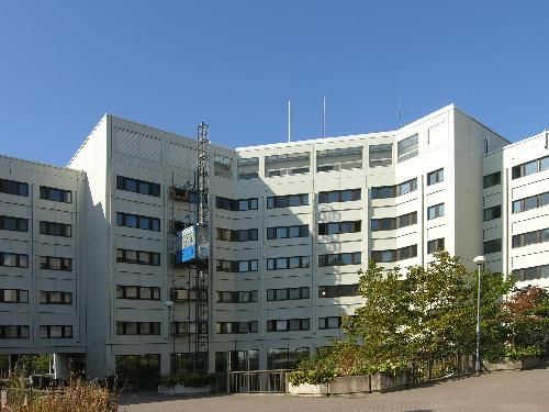 Valkoinen monikerroksinen rakennus kirkkaan sinisen taivaan alla.