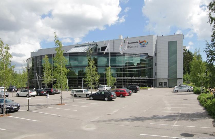 Moderni toimistorakennus ja sen edessä sijaitseva parkkipaikka.