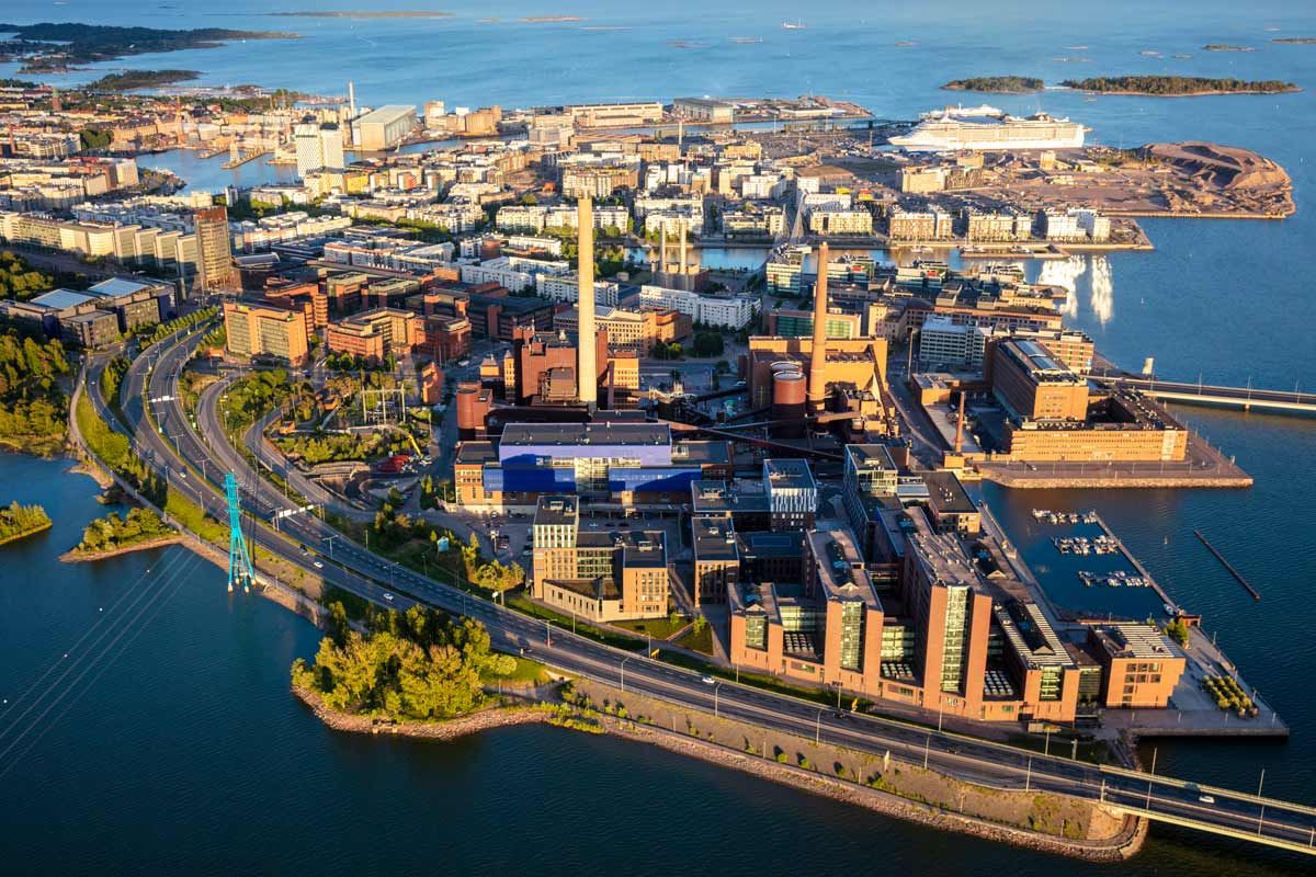 Ilmakuva Helsingin Ruoholahdesta ja Salmisaaren voimalaitoksesta meren rannalla.