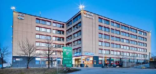 Monikerroksinen toimistorakennus iltahämärässä.