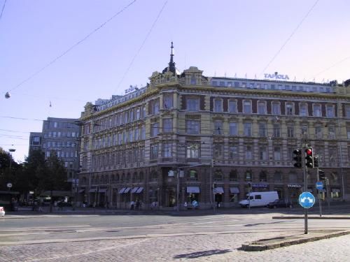 Koristeellinen rakennus kadun kulmassa kaupunkimiljöössä.