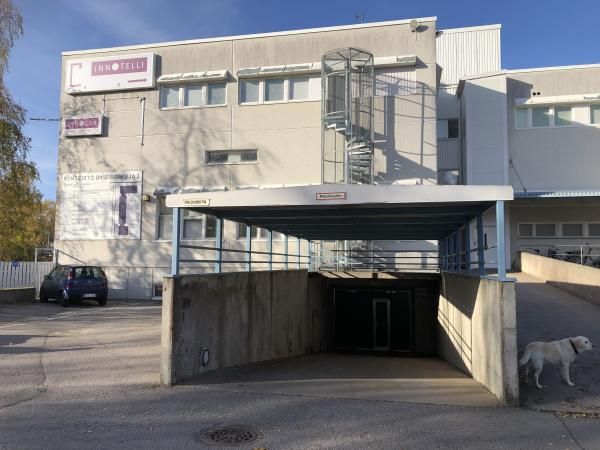 Innotelli-toimistorakennus, jonka edustalla on ramppi parkkihalliin, ulkoiset kierreportaat ja va...