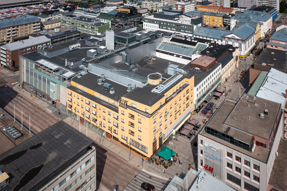 Korkealta otettu kuva kaupungin keskustan rakennuksista ja kävelykaduista.