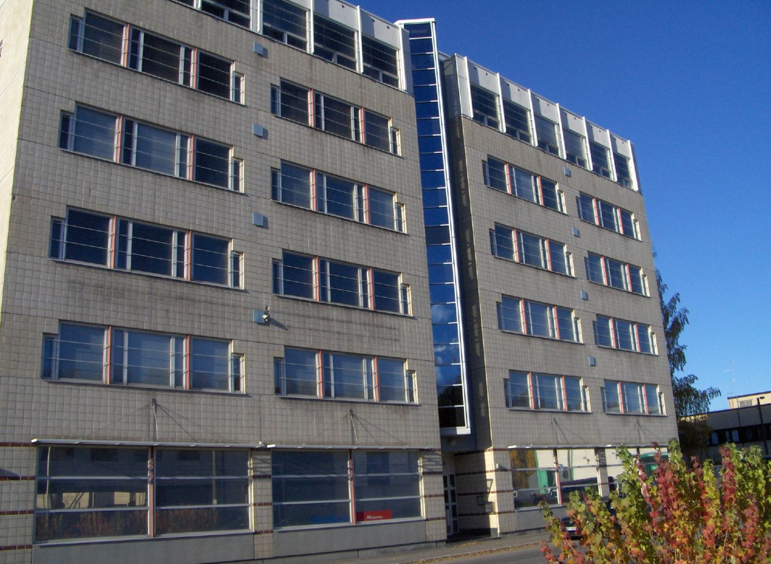 Harmaa monikerroksinen rakennus, jossa on laatoitettu julkisivu.