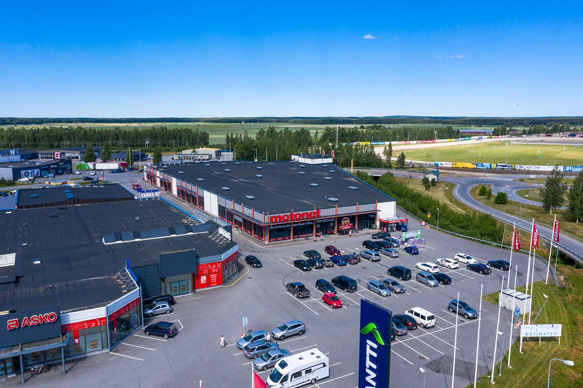 Ilmakuva liikealueesta, jossa on Motonet- ja Asko-myymälät sekä laaja pysäköintialue.