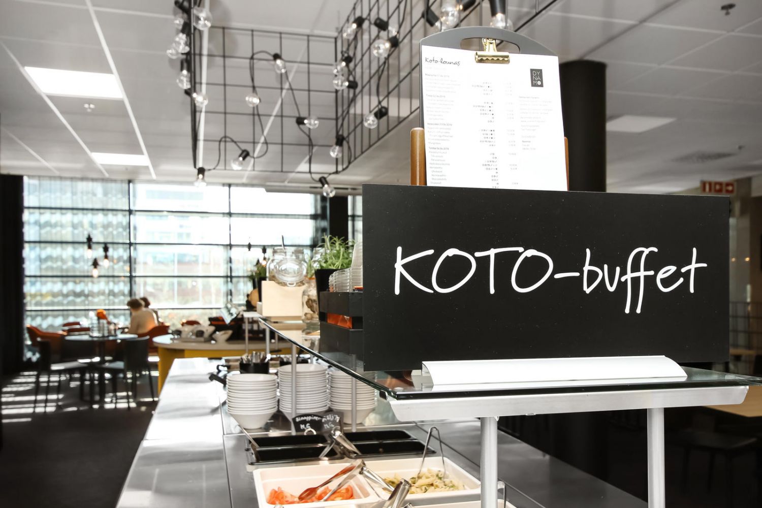 Ravintolan noutopöytä, jonka etualalla on musta KOTO-buffet-kyltti.