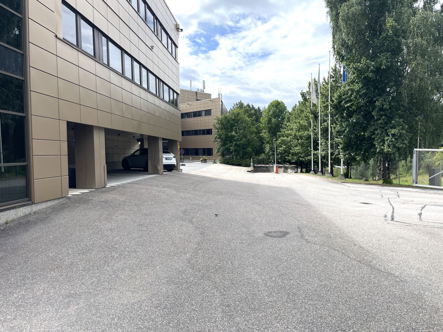 Moderni toimistorakennus ja asfaltoitu piha-alue.
