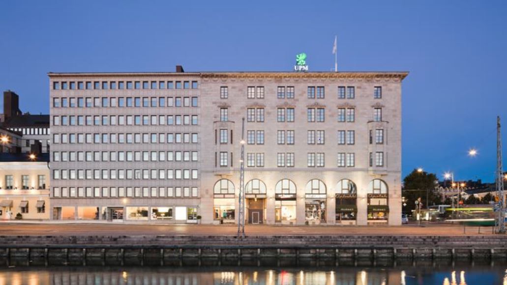 UPM:n toimistorakennus rannalla iltahämärässä.
