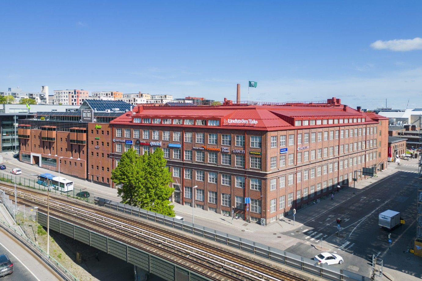 Ilmakuva punatiilisestä Lindström Talosta ja sitä ympäröivästä kaupunkimaisemasta.