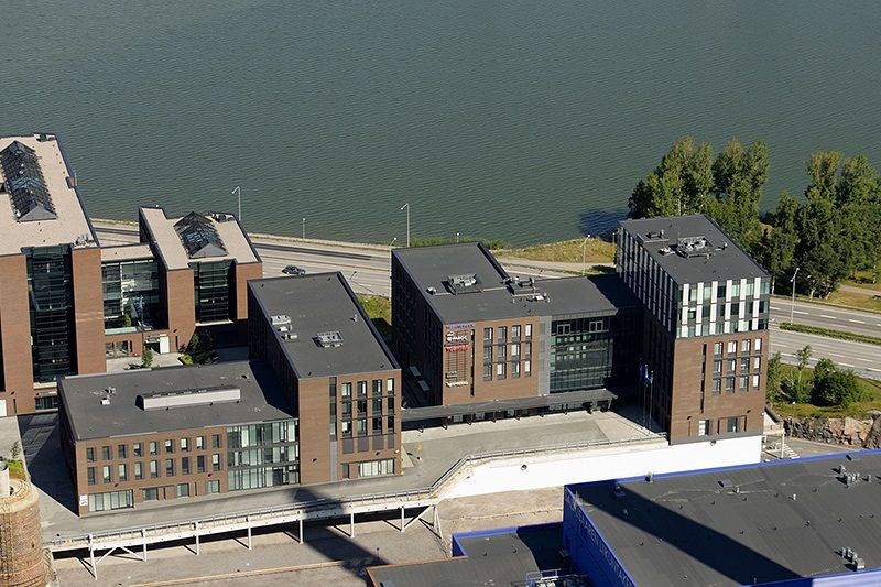 Ilmakuva moderneista toimistorakennuksista meren rannalla.