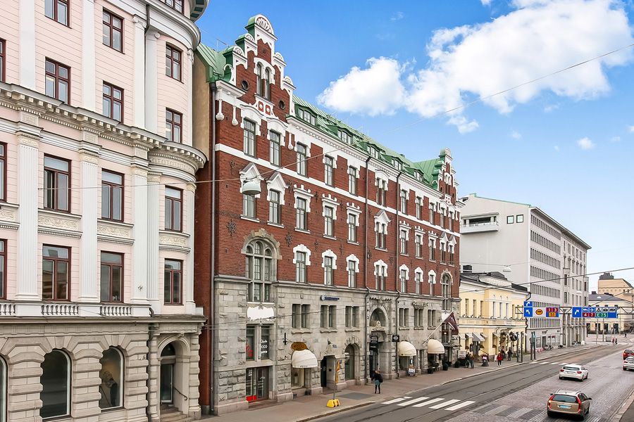 Kaupunkinäkymä, jossa on koristeellisia historiallisia rakennuksia kadun varrella.