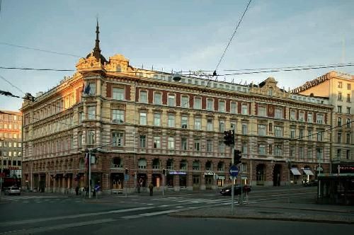 Historiallinen rakennus katujen risteyksessä kaupunkiympäristössä.