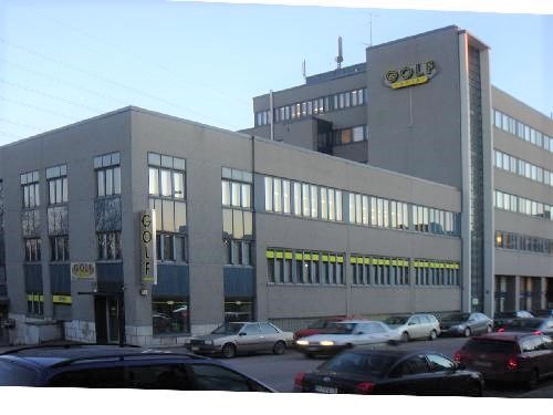 Monikerroksinen rakennus ja autoja kadulla.
