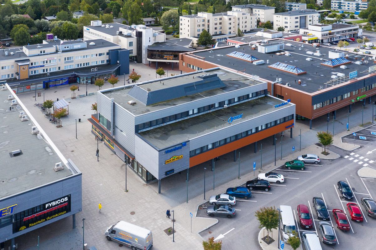 Ilmakuva liikekeskuksesta, sen rakennuksista ja viereisestä pysäköintialueesta.